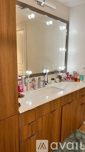 A bathroom vanity with a mirror and lights above it.