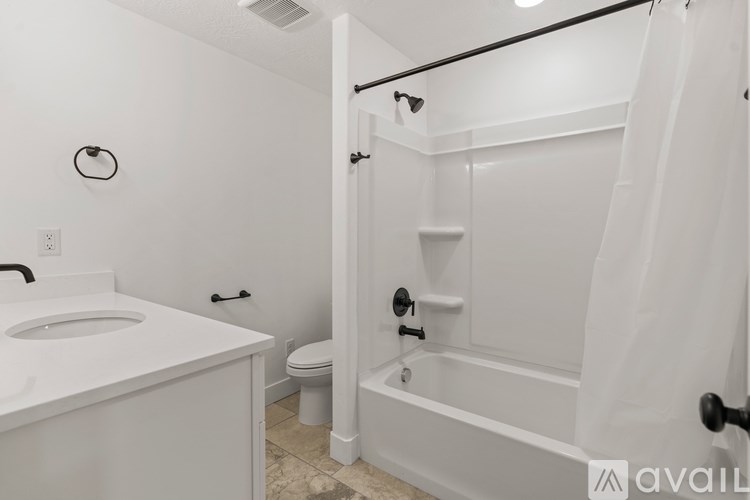A white bathroom with a toilet, sink, and bathtub.