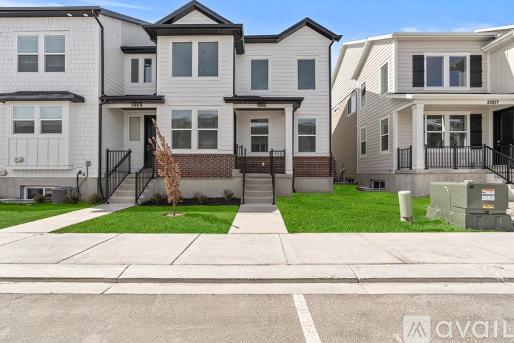 A row of houses with the first one on the left having a white door and the second one having a black door.