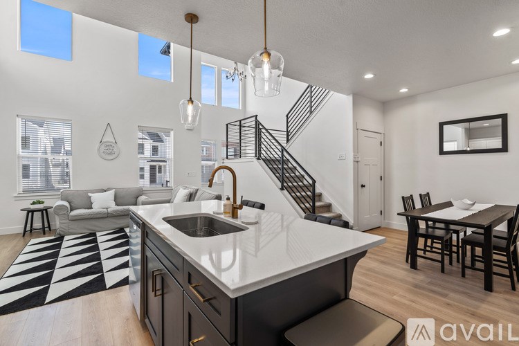 A modern kitchen with a large island and a dining table.