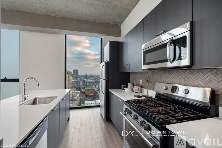 A modern kitchen with a stove top oven and a microwave above it.