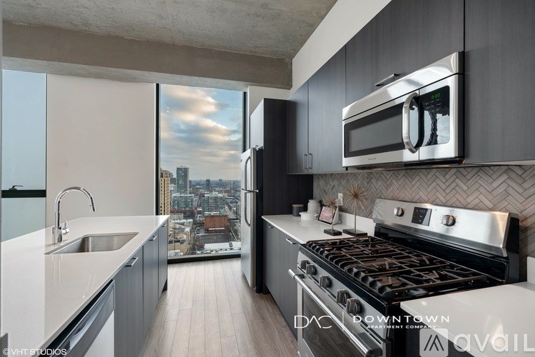 A modern kitchen with a stove top oven and a microwave above it.