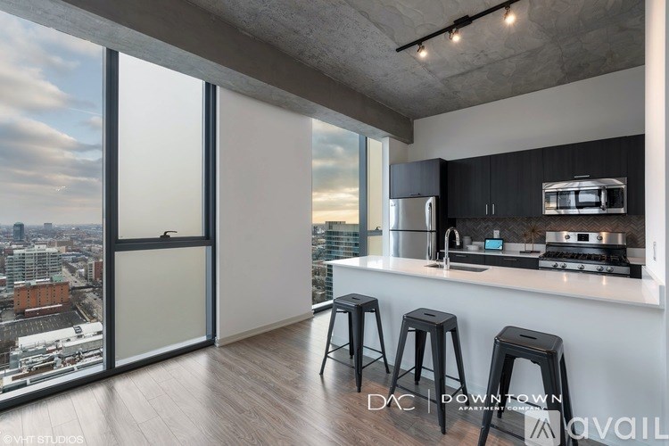 A modern kitchen with a view of the cityscape outside the large window.