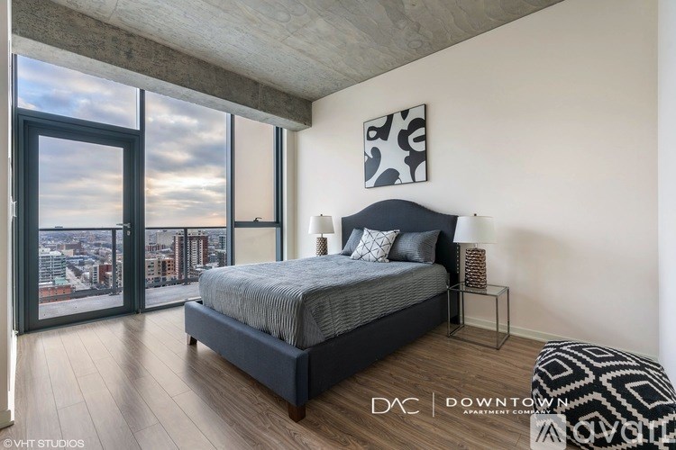 A bedroom with a large bed and a view of the city.