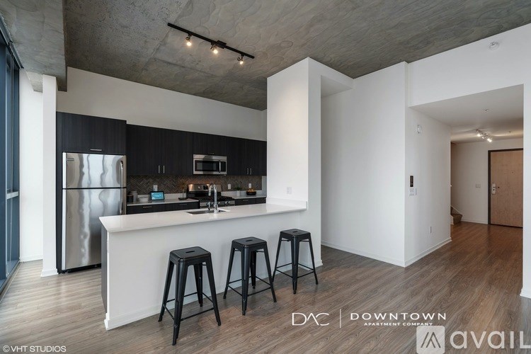 A modern kitchen with a bar area and stools.