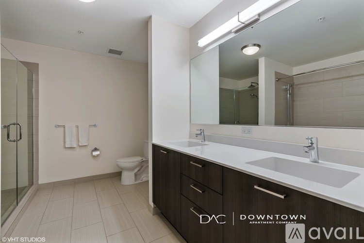 A bathroom with a toilet, sink, and mirror.