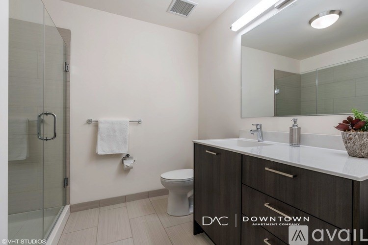 A bathroom with a toilet, sink, and mirror.