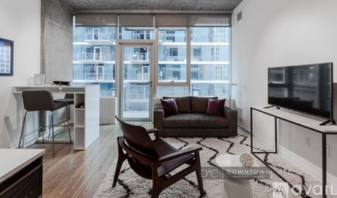 A living room with a brown leather chair and a white couch.