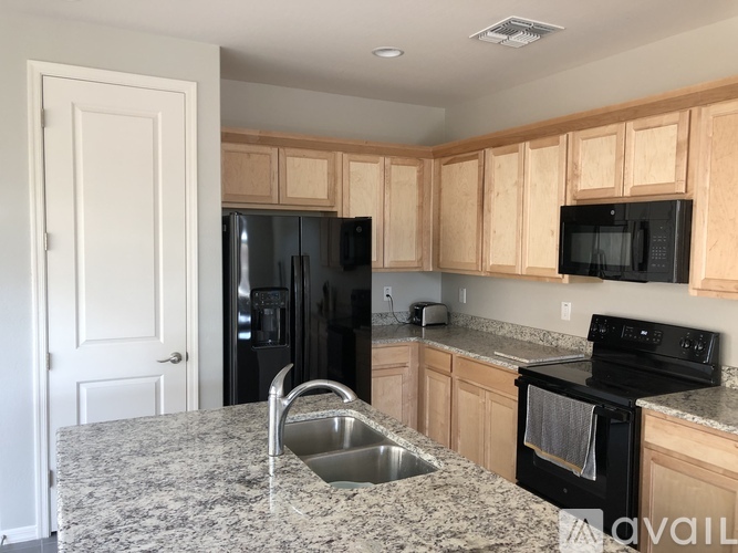 A kitchen with granite countertops and wooden cabinets.