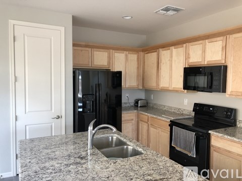 A kitchen with granite countertops and wooden cabinets.