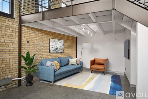 A living room with a blue couch and a brown chair.