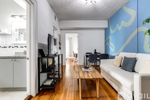 A living room with a white couch and a wooden coffee table.