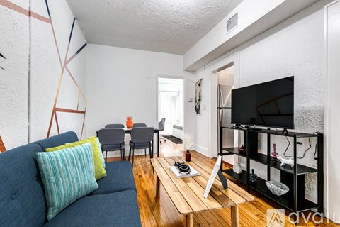 A living room with a blue couch, a wooden coffee table, and a television.