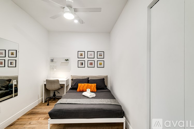 A bedroom with a bed, desk, and chair.