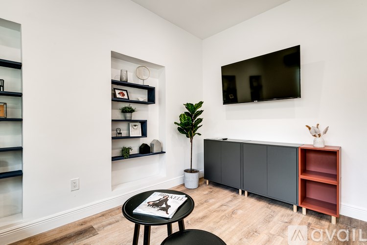A living room with a black table and a television on the wall.