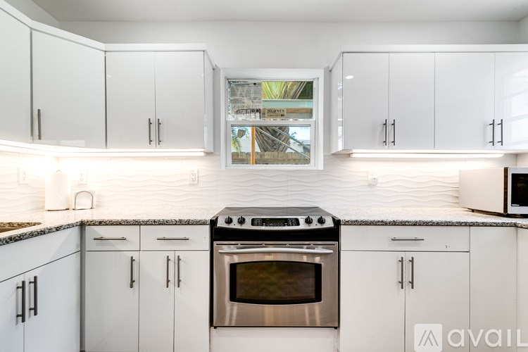 A kitchen with white cabinets and a stainless steel oven.