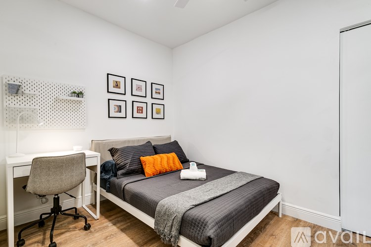 A bedroom with a bed, desk, and chair.