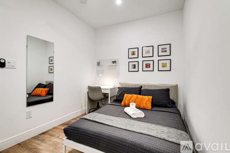 A bedroom with a bed, a chair, and pictures on the wall.