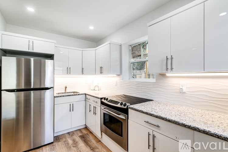 A modern kitchen with a stainless steel refrigerator and a granite countertop.
