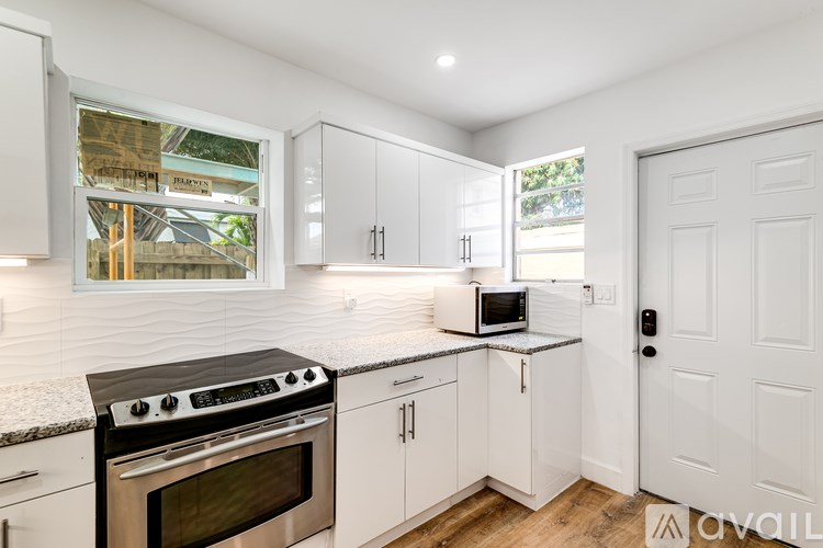 A kitchen with white cabinets and a black stove top oven.