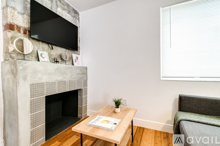 A living room with a fireplace and a flat screen TV mounted above it.