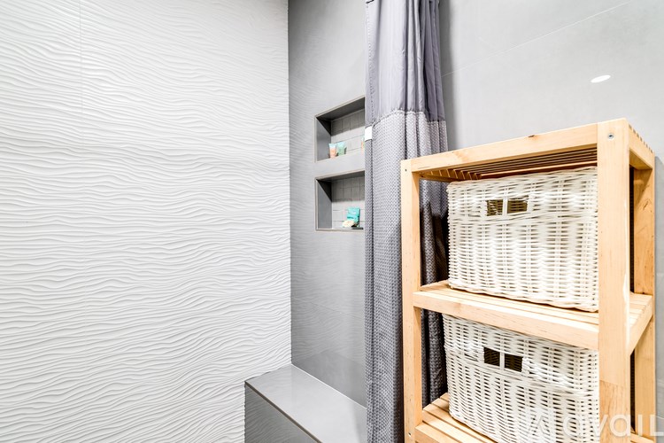 A wooden shelf with three white baskets on top.