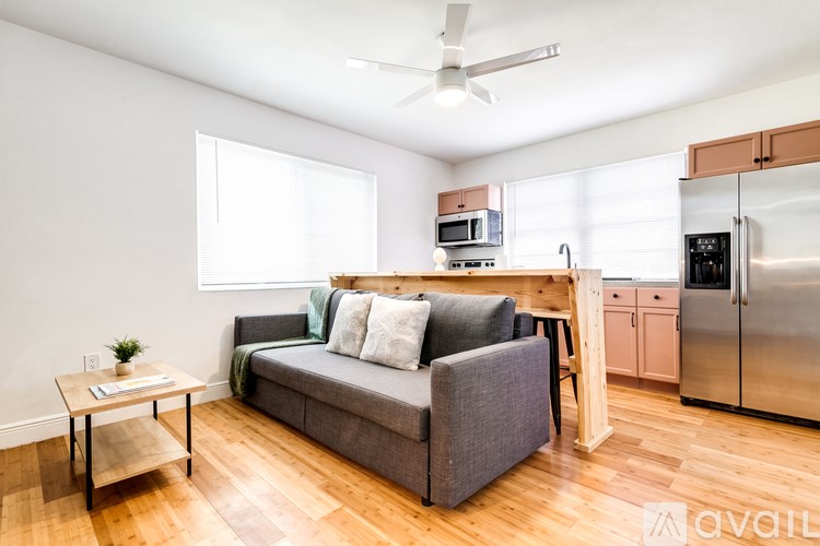 A living room with a grey couch and a wooden table.