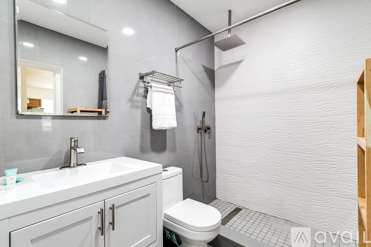 A modern bathroom with a white toilet and a walk-in shower.