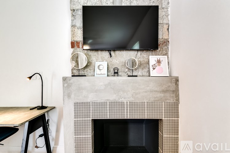 A fireplace with a TV above it and a table below.