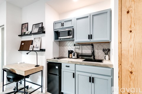 A kitchen with a black dishwasher and a wooden table.