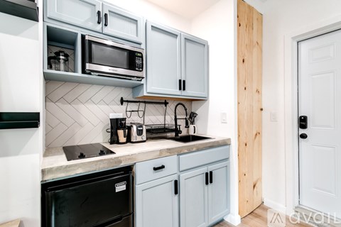 A kitchen with a black dishwasher and a black microwave.