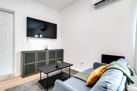 A living room with a grey couch and a black coffee table.