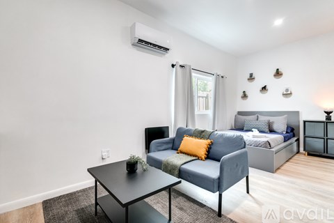 A modern bedroom with a blue bed and a black coffee table.