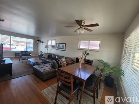 A living room with a brown wooden table and chairs.