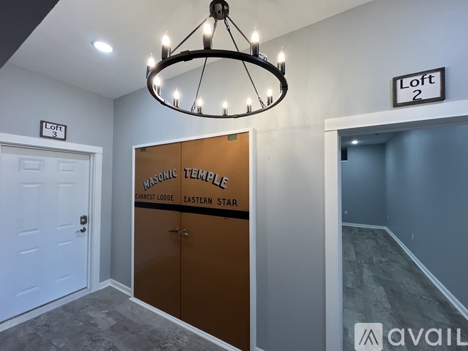 A room with a chandelier and a sign that says "Loft 2".