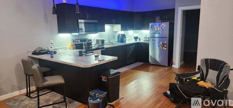 A kitchen with a black counter top and a white fridge.