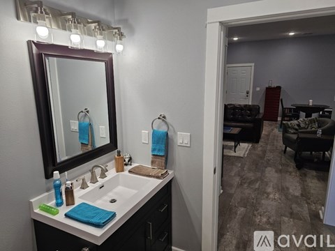 A bathroom with a sink, mirror, and lights above it.
