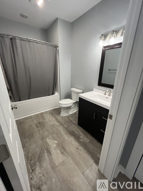 A bathroom with a toilet, sink, and shower.