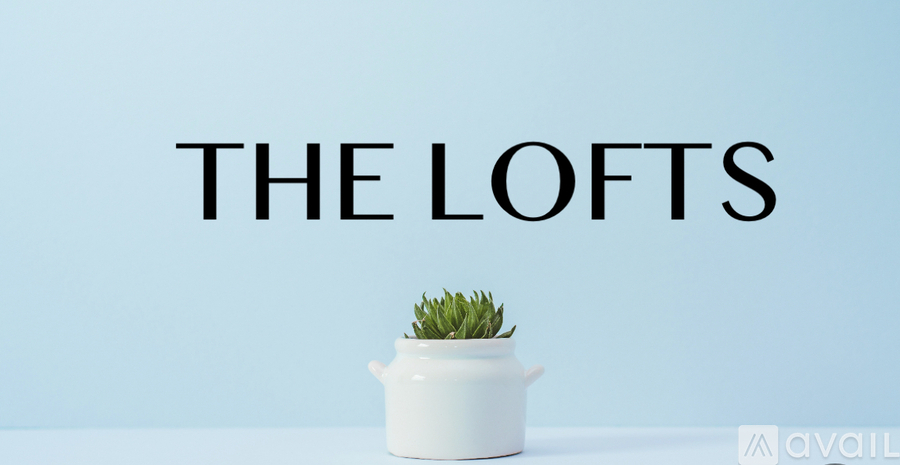A white pot with a plant on a light blue background with the text "THE LOFTS" above it.