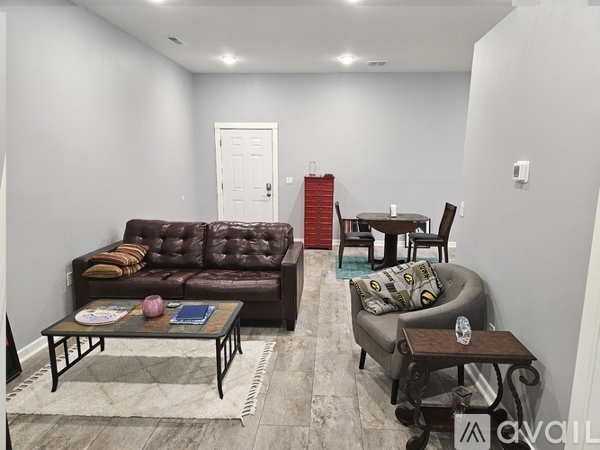 A living room with a brown couch and a glass coffee table.