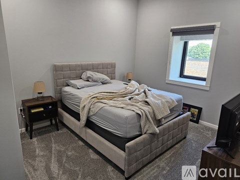 A bedroom with a large bed and a window.