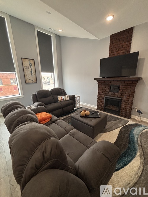 A bedroom with a bed, chair, and a door.