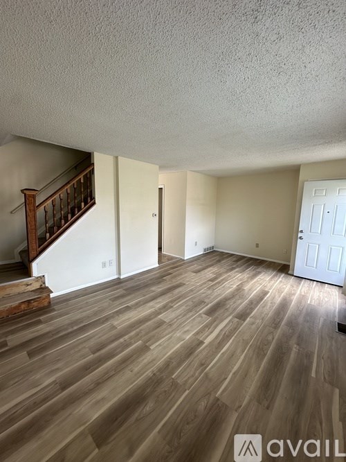 A room with wooden flooring and a staircase.