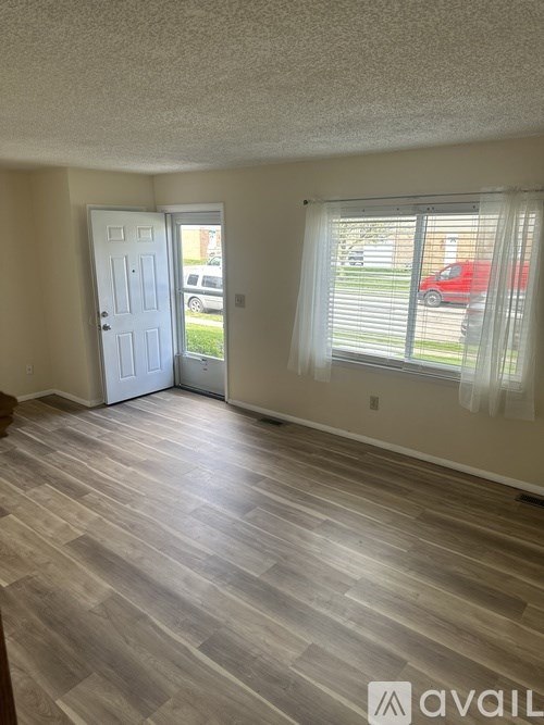 A room with a door and a window with blinds.