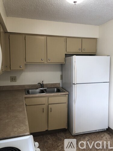 A kitchen with a white fridge and cabinets.