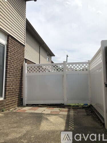 A white gate is closed and locked.