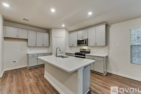 A kitchen with white cabinets and a large island.