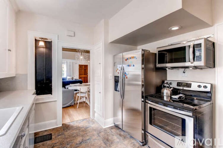 A kitchen with a refrigerator, oven, and microwave.