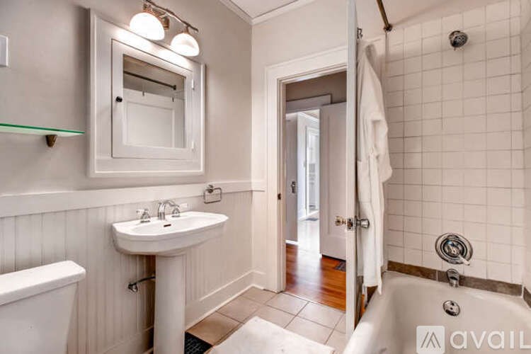 A bathroom with a white tub, sink, and toilet.