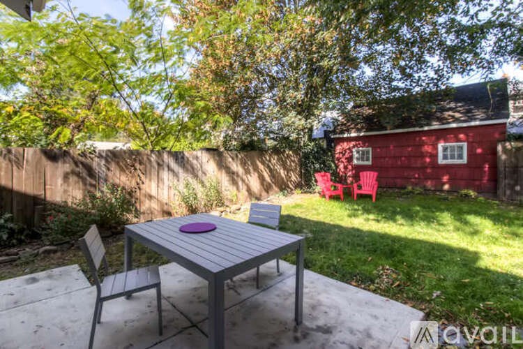 A grey table and two chairs are set up on a patio.